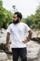 An African Man With White Shirt Posing Near a River in the Nature