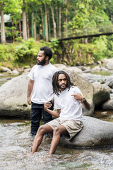 Two Young African Man With White Shirt Posing Above a Rock in the Nature