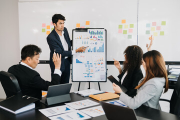 Office colleagues have a casual discussion. During a meeting in a conference room, a group of business teem sit in the conference room