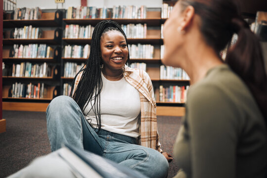 University, Students And Friends On Library Floor For Studying, Education And Learning Together. Happy Black Girl, Gen Z Youth And College Student At Academy, Campus And School In Room With Bookshelf