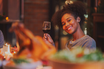 happy family Christmas dinner party African American woman sitting at Christmas festive table celebrating winter holiday with family enjoying in Thanksgiving dinner party at dining table.