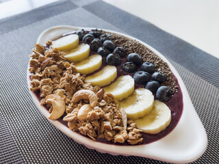Blueberry yoghurt bowl with granola, banana and chia seeds. Healthy boost breakfast concept