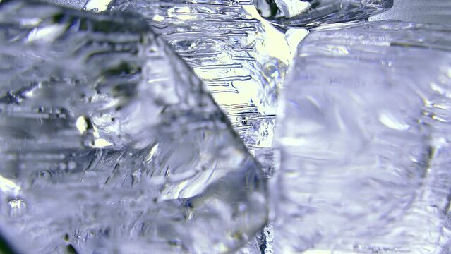 Pieces of ice with frozen air bubbles shine through with light. Frozen water from permafrost. Fresh frosty background and texture.