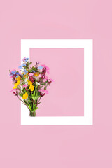 Spring wildflower posy, white frame on pink background. Minimal abstract border nature composition for Valentines Day, Mothers Day, Easter, birthday. British flora. Medicinal herbs and flowers.
