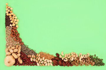 Health food collection high in lipids. Ingredients contain unsaturated good fats for healthy heart and cholesterol levels with nuts, seeds, legumes and grain. On green background. Top view.
