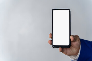 Hand using white smartphone screen on gray surface background, close-up top view