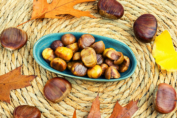 Peeled roasted chestnuts and autumn leaves
