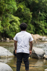 An African Man With White Shirt Posing Near a River in the Nature