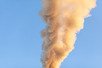 White thick smoke from the boiler room chimney. Smoke against the blue sky. Air pollution. Heating...