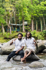 Two Young African Man With White Shirt Posing Above a Rock in the Nature