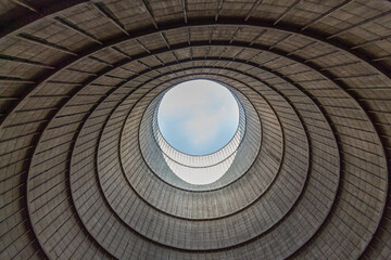 Inside a cooling tower of a nuclear power plant. View upwards, blue sky. abandoned place - obrazy, fototapety, plakaty