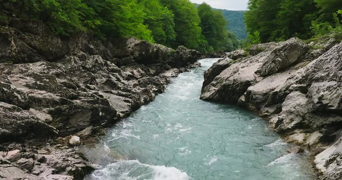 Aerial view of Mountain river and road. Flying over a mountain gorge. Slow motion 120 fps.