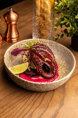Octopus with rice, beetroot sauce and lime
