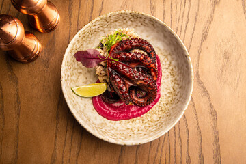 Octopus with rice, beetroot sauce and lime