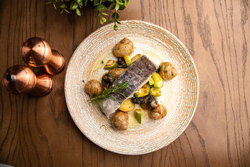 Baked fish with snails and vegetables