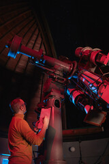 Astronomer with a big astronomical telescope in observatory doing science research of space and...