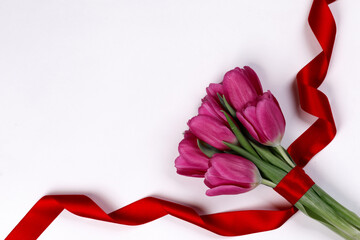 Tulip flowers and ribbon on white