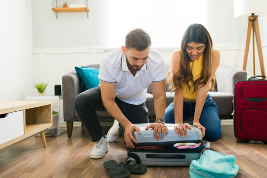 Couple Having Problems Packing Their Suitcases