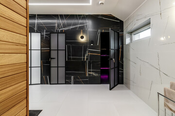Modern room finished with black marble near the entrance to the bath area and bathroom