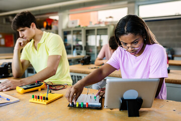 Hispanic latin young female student learning electronics at high school lesson. Education lifestyle concept