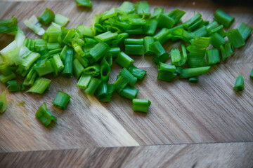 chopped green onions on a wooden board