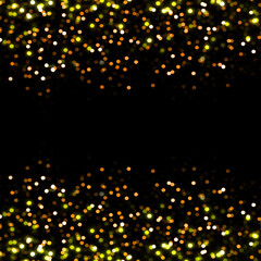 Gold abstract bokeh covered with blurred shiny particles on top side as decorative cover on black background
