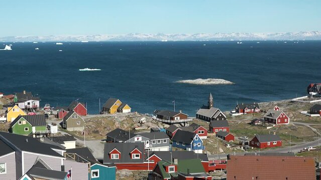 The colorful settlement in central-western Greenland. A typical village in Greenland with colorful houses. Greenlandic fishing town, Old wooden church, town life, beautiful series of Arctic life.