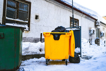 Yellow plastic dumpster with black bags