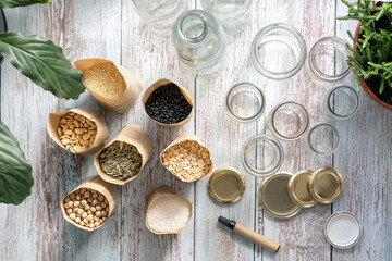 Wooden table top view of bulk food and empty recycled jars and a marker for labeling jars.