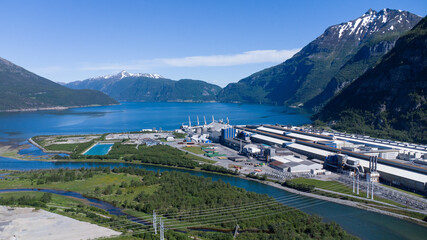 Sunndalsøra, Norway - June 19, 2022: Aerial view of the Hydro Norse aluminium production facility placed in a beautiful landscape - obrazy, fototapety, plakaty