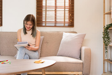 Creative design concept, Fashion designer sits on couch and drawing to create new collection dress