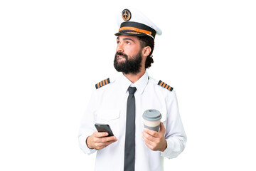 Airplane caucasian pilot man over isolated chroma key background holding coffee to take away and a...