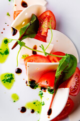 Italian Caprese salad with tomato and cheese in white plate