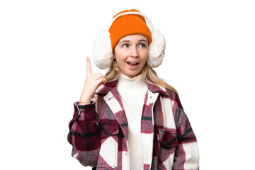 Young  English woman wearing winter muffs over isolated background intending to realizes the solution while lifting a finger up