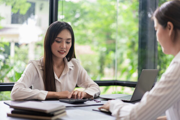 Coworker business concept, Two businesswoman discussing and calculating cost of business project