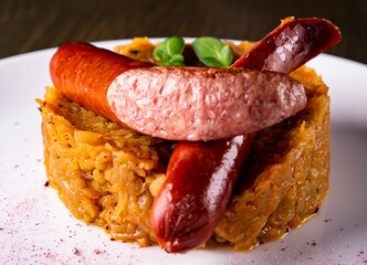 Fried cabbage with sausage in white plate