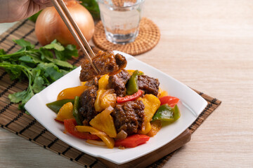 Sweet and sour sauced deep fried pork ribs with chopped pepper and pineapple.