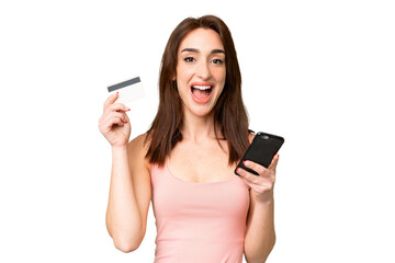 Young caucasian woman over isolated chroma key background buying with the mobile and holding a...