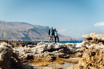 Happy couple walking and hugging on the shores of the mediterranean sea