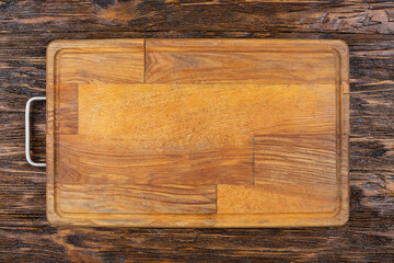 Empty old cutting board on a wooden background. Layout for the recipe.