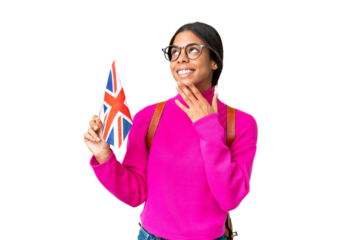 Young African American woman holding an United Kingdom flag over isolated chroma key background looking up while smiling