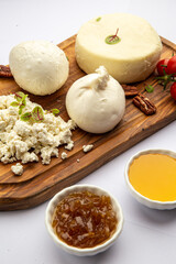 Obraz na płótnie Canvas Assorted cheeses on a board with honey and jam