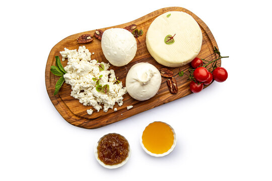 Assorted cheeses on a board with honey and jam