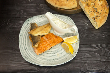 fried breaded fish with white sauce and lemon