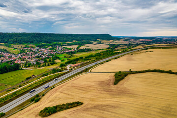 Aerial bird view of typical Ardennes green field meadows and hill landscape also showing highway...