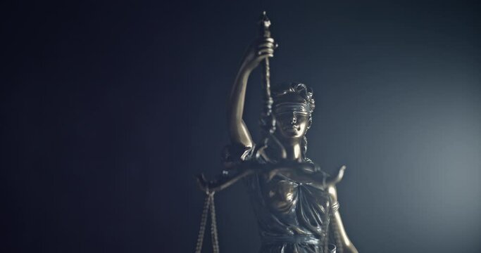 Legal law, patent attorney or successful lawyer concept. Bronze statue of themis or lady of justice on black background.