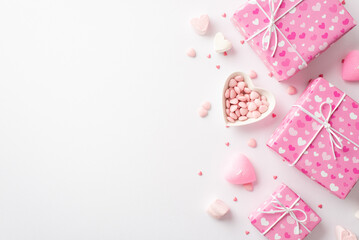 Valentine's Day concept. Top view photo of pink gift boxes heart shaped saucer with sprinkles marshmallow and candles on isolated white background with copyspace