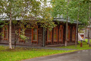 Reiny clouds in the cold autumn sky over  village with small wood log local houses and low fences in the park. Travelling on the suburb roads. People living