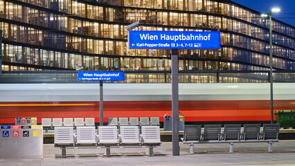 Vienna central station Hauptbahnhof sign on train platform, at night. Main railway transportation hub in Wien, Austria. - Powered by Adobe