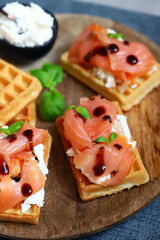 Delicious salmon sandwiches with white cheese on waffles.